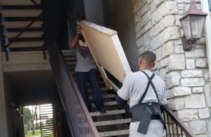 Small Move Same Day Fort Worth professional apartment movers navigating stairs while carrying heavy furniture at a Fort Worth apartment complex