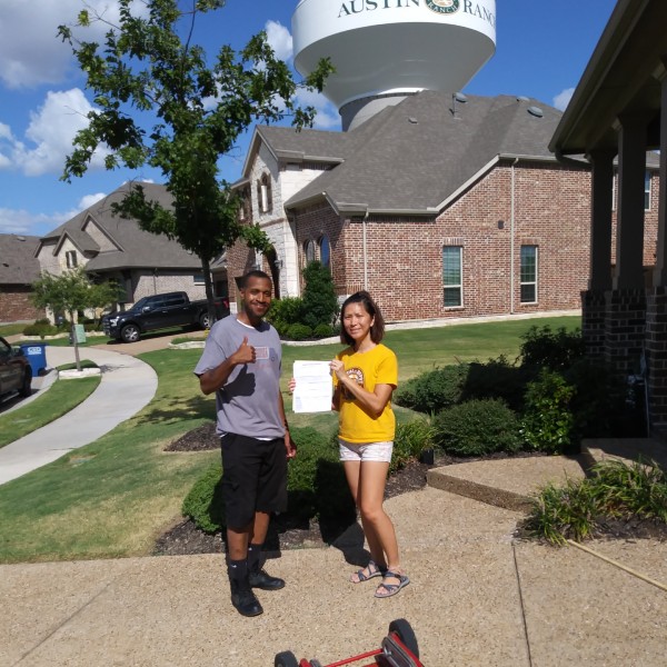 Professional movers in Fort Worth standing with a satisfied customer in front of her new home after a successful local move.