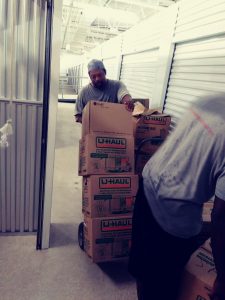 Professional movers in Fort Worth carefully loading a storage unit with U-Haul boxes for a residential move