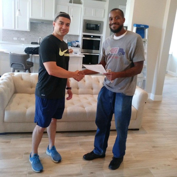 A satisfied customer shaking hands with a professional mover from Small Move Same Day Fort Worth after a successful last-minute move.